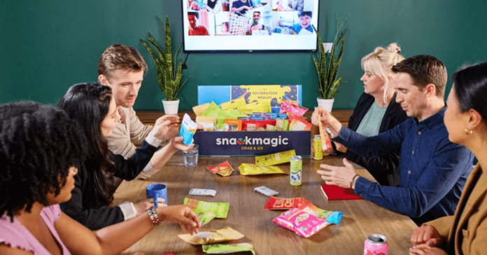 meeting with snacks shared on the table in front of a TV screen
