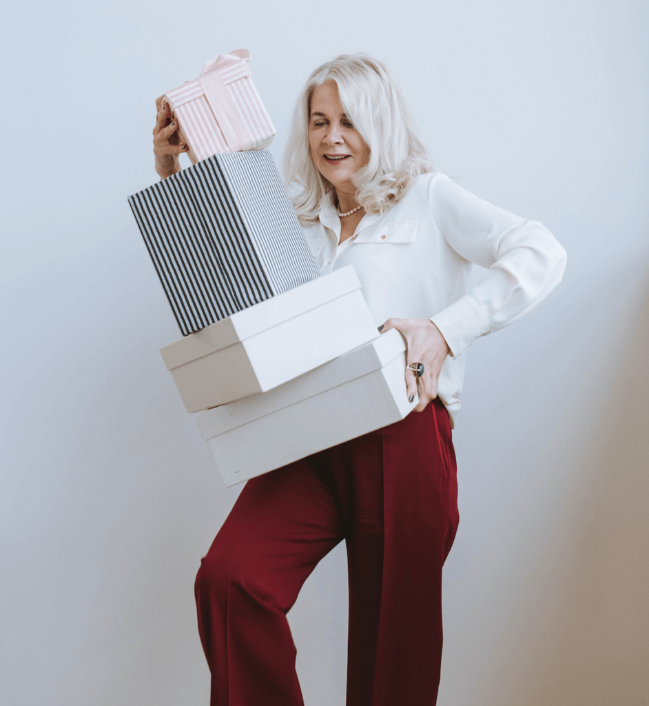 woman with silver hair carrying giftboxes