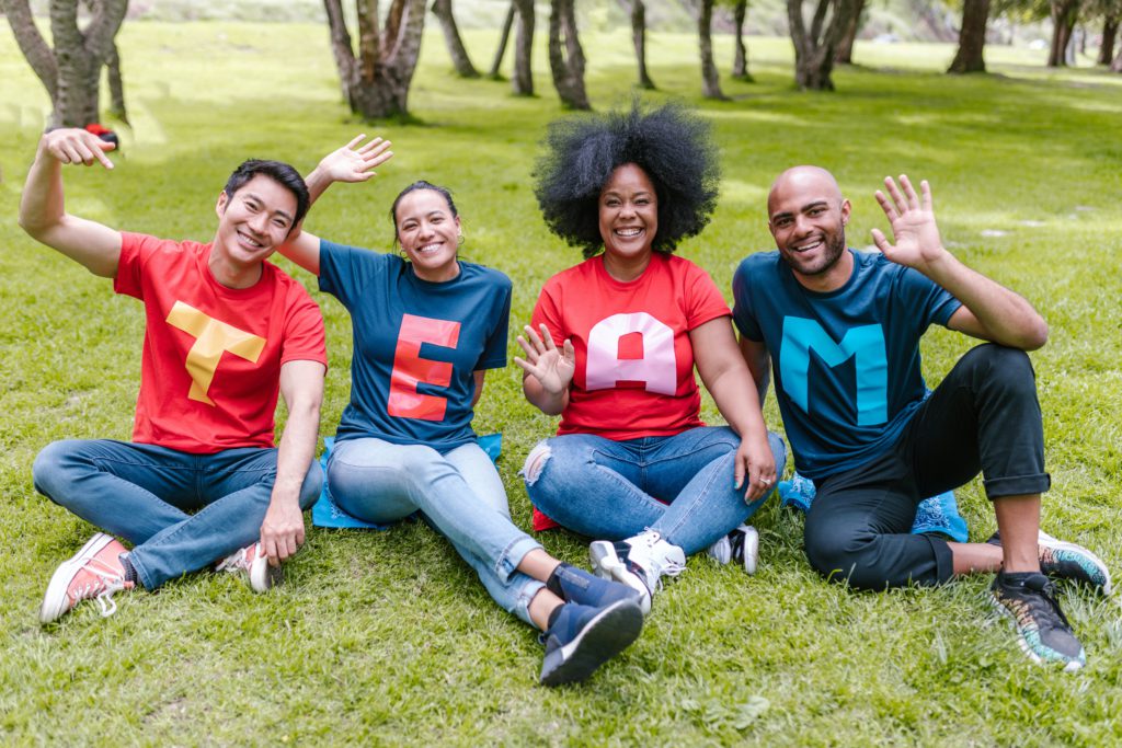 4 people wearing shirts that spell TEAM