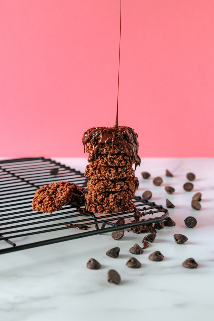 Chocolate drizzling on top of zucchini brownies with chocolate chips.