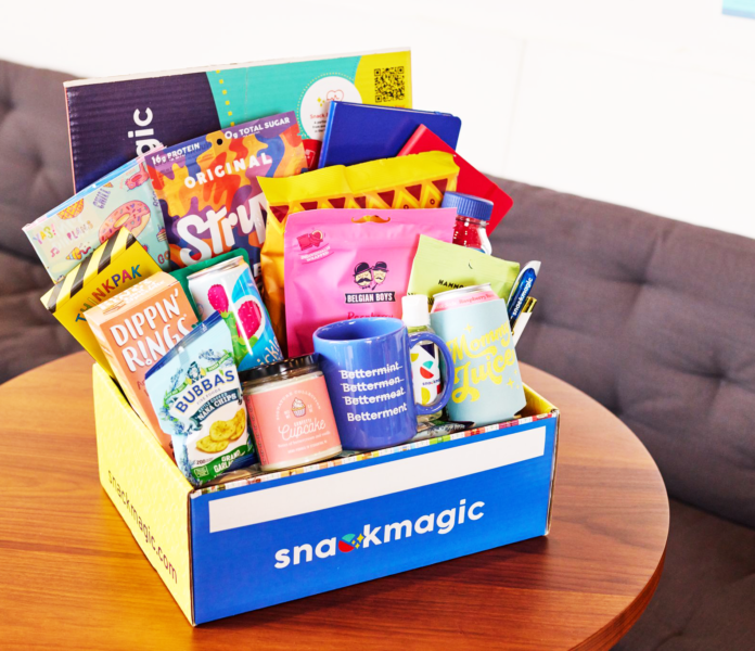 A fully stacked SnackMagic box full of treats and gifts on a conference table.