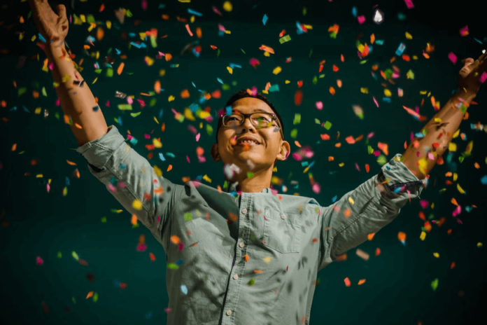 An employee celebrating with confetti in mid-air.