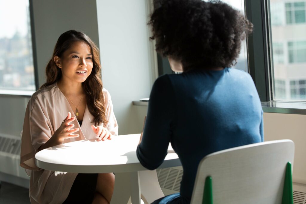Two women having a friendly conversation in an office.