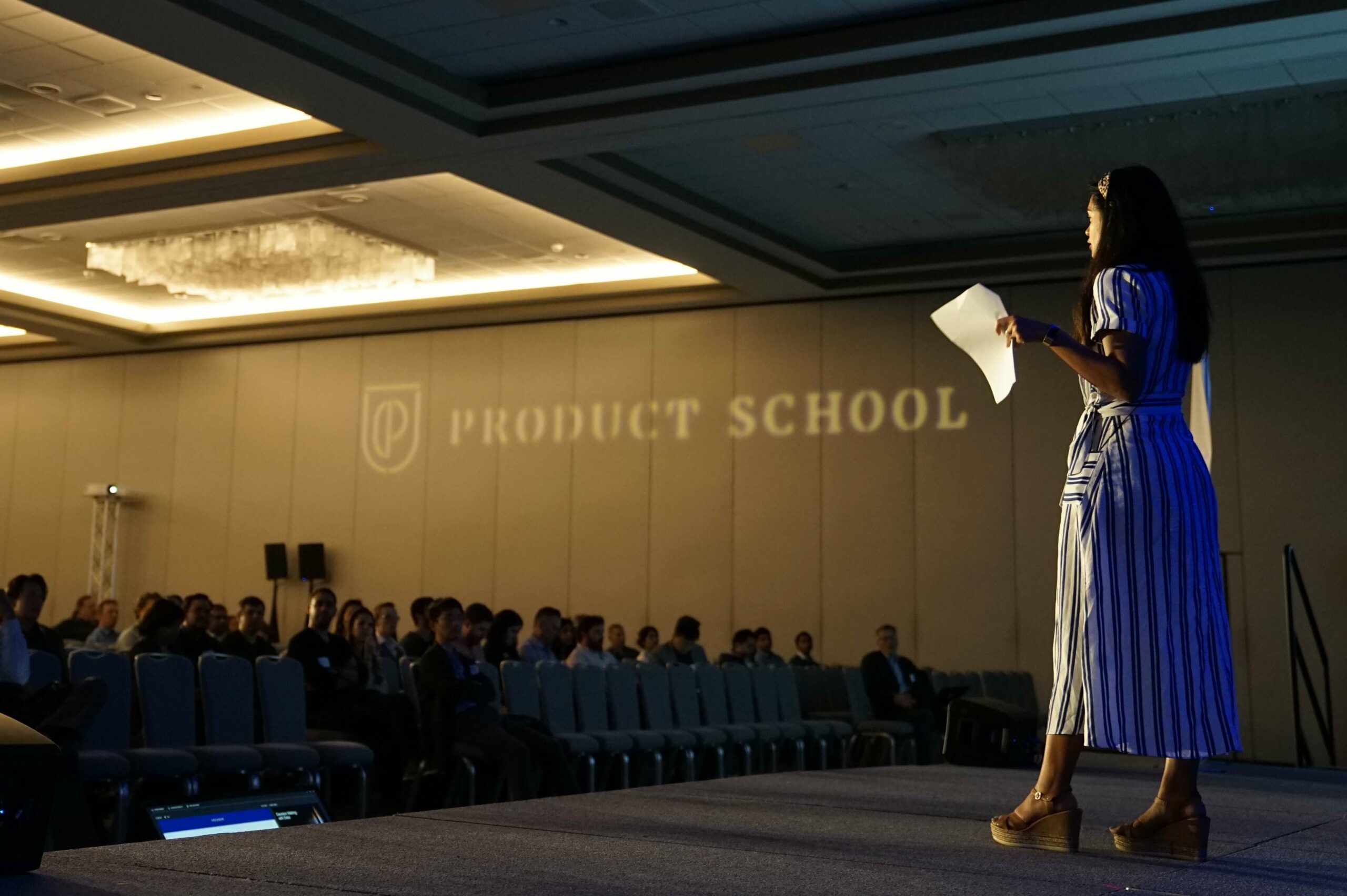 A woman addressing a large crowd at a professional conference.