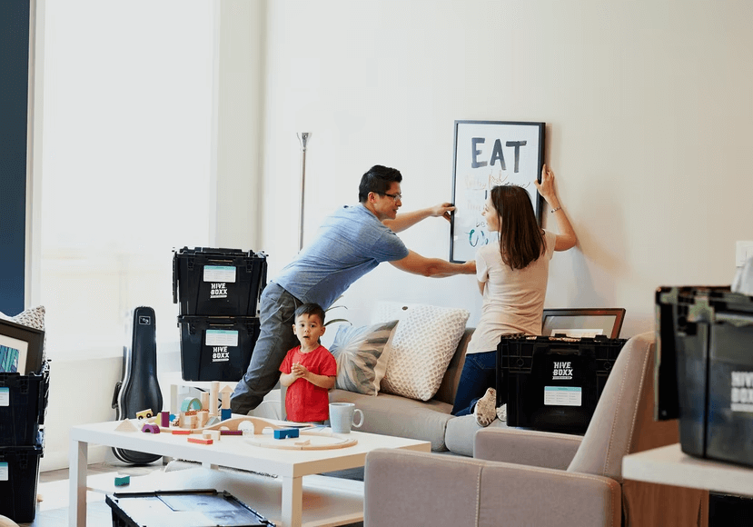 A young family unpacking decorations for their new home.