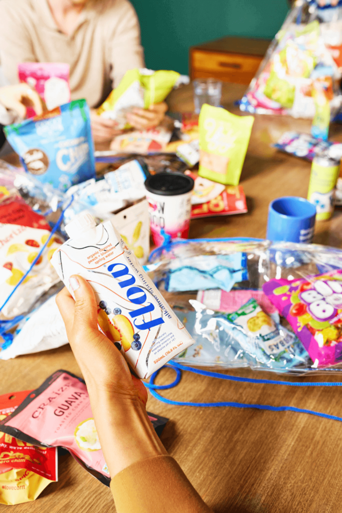 A huge variety of snacks and sips from SnackMagic spread out on a conference room table.
